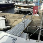 A boat ramp with a handrail going to the dock